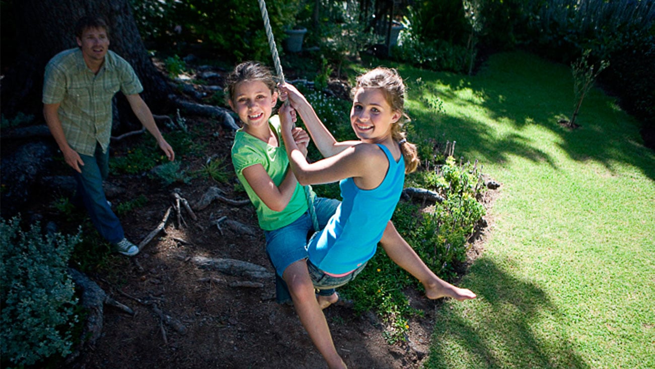 Two children sitting on a rope swing