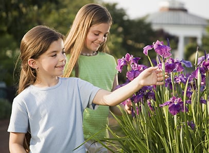 Children admiring flowers at a park