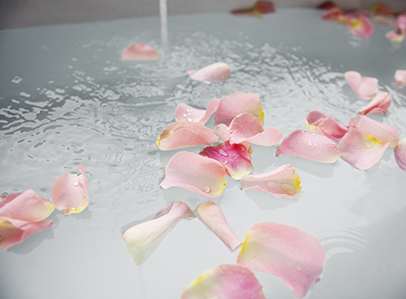 Pétalos de rosa flotando sobre el agua de una bañera