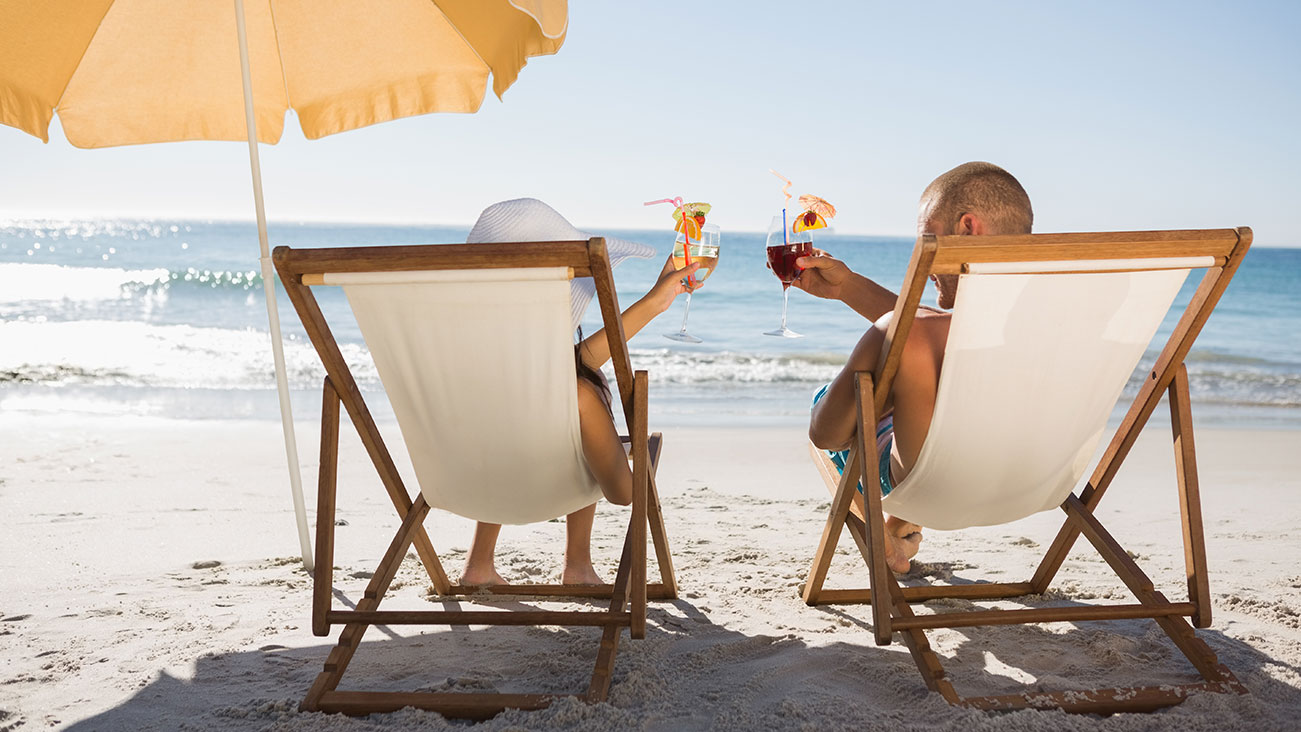 Una pareja sentada en sillas de playa en la playa